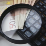 Analyse détaillée des coûts de création d'un site internet professionnel : billets, calculatrice et loupe symbolisant l'expertise et la transparence