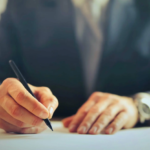 Un homme d'affaires signe un contrat, illustrant l'importance des mots-clés transactionnels pour convertir les visiteurs de site web en clients.